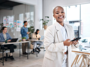 Phone, accountant and portrait of black woman, happy and smile in company, business workplace or coworking. Smartphone, face of auditor and excited African professional, entrepreneur or employee